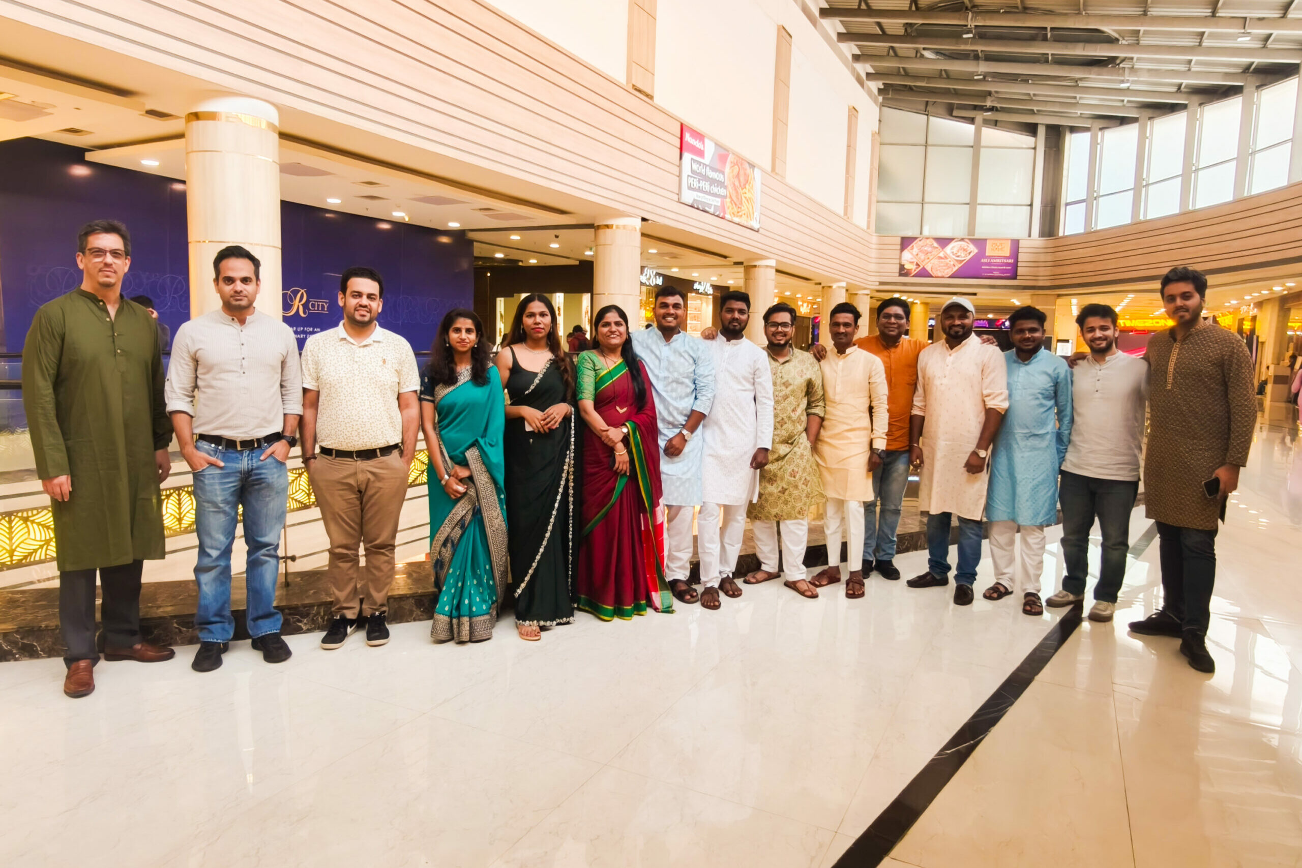 Group of diverse colleagues celebrating together in a shopping mall for a team event or gathering.